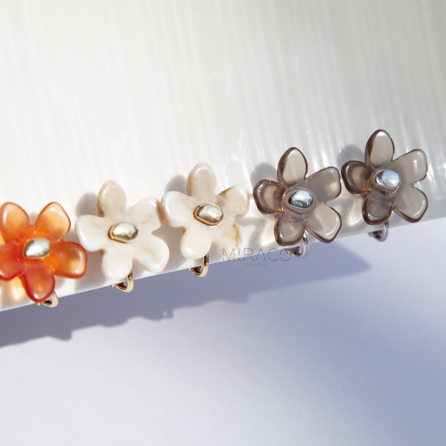 Bloom with Effortless Style – Add a delightful touch of floral charm to your look with these adorable flower stud earrings, designed specifically for comfortable clip-on wear. Crafted from polished resin with a lovely translucent or marbled quality, these earrings capture the light beautifully. Each flower features a chic gold-tone center accent.
Available in four versatile color options Smoky Taupe, Vibrant Orange, Cream Marble, Jade Green there's a perfect pair for every mood and outfit!
