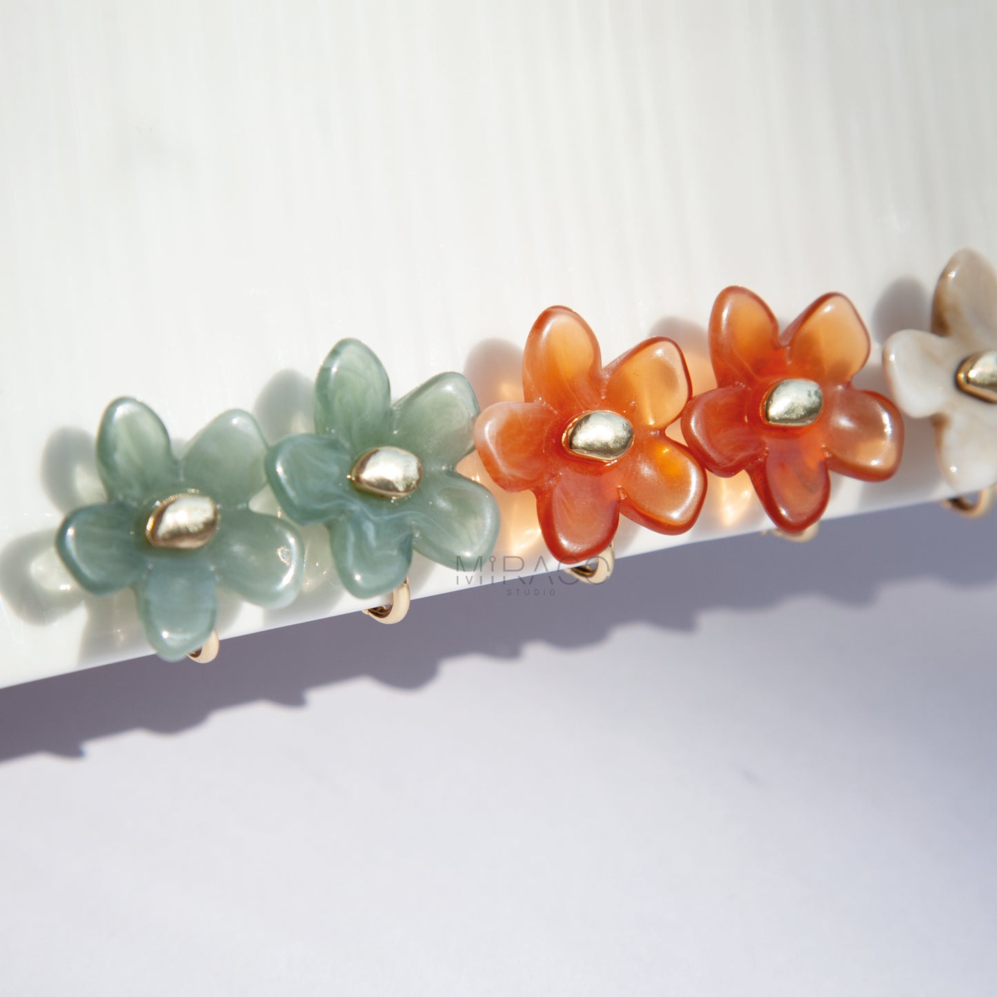 Bloom with Effortless Style – Add a delightful touch of floral charm to your look with these adorable flower stud earrings, designed specifically for comfortable clip-on wear. Crafted from polished resin with a lovely translucent or marbled quality, these earrings capture the light beautifully. Each flower features a chic gold-tone center accent.
Available in four versatile color options Smoky Taupe, Vibrant Orange, Cream Marble, Jade Green there's a perfect pair for every mood and outfit!