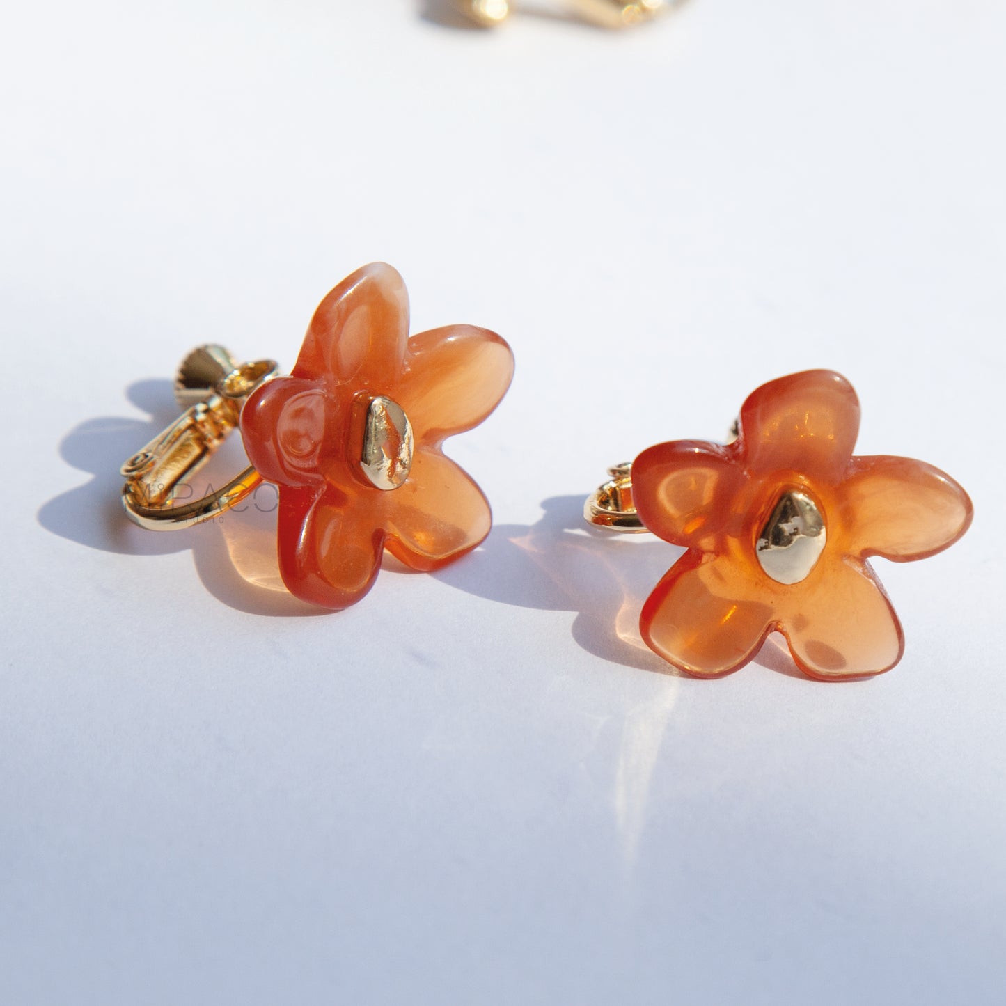 Bloom with Effortless Style – Add a delightful touch of floral charm to your look with these adorable flower stud earrings, designed specifically for comfortable clip-on wear. Crafted from polished resin with a lovely translucent or marbled quality, these earrings capture the light beautifully. Each flower features a chic gold-tone center accent.
Available in four versatile color options Smoky Taupe, Vibrant Orange, Cream Marble, Jade Green there's a perfect pair for every mood and outfit!