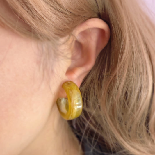 Classic Hoops, Modern Comfort – No Piercing Required! Get the timeless appeal of hoop earrings with the ultimate convenience of clip-ons! These eye-catching hoops are crafted from beautifully marbled resin, featuring unique swirls of color that add a touch of artistic flair to any outfit. Available in two chic colorways – Amber Swirl and Cream Swirl – they offer versatile style options.