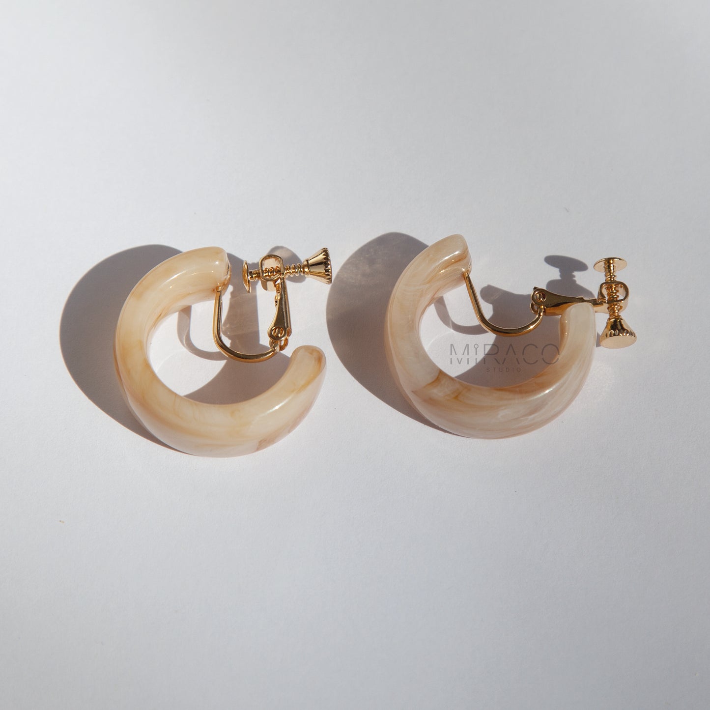 Classic Hoops, Modern Comfort – No Piercing Required! Get the timeless appeal of hoop earrings with the ultimate convenience of clip-ons! These eye-catching hoops are crafted from beautifully marbled resin, featuring unique swirls of color that add a touch of artistic flair to any outfit. Available in two chic colorways – Amber Swirl and Cream Swirl – they offer versatile style options.