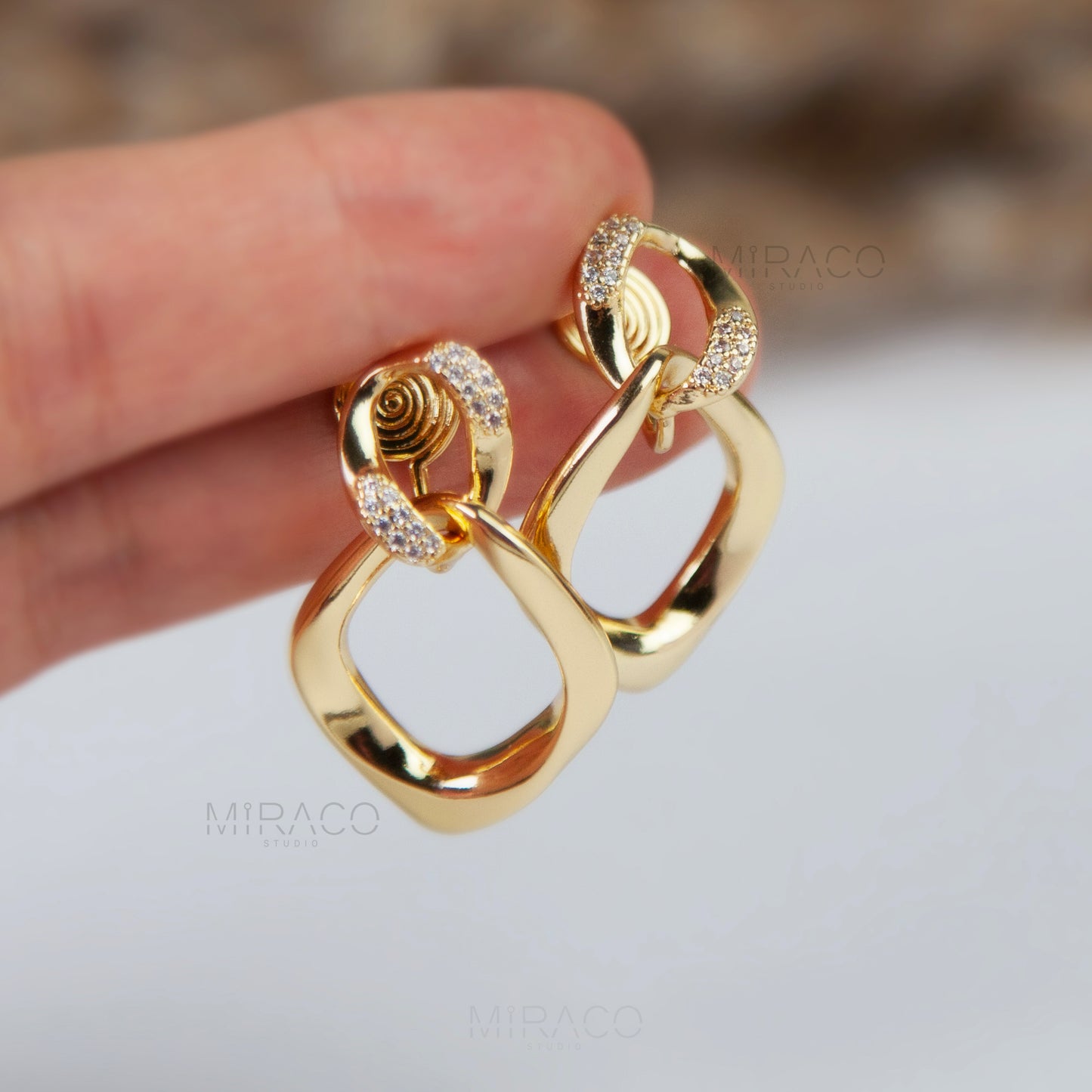 Elevate your style with these stunning gold color dangle earrings featuring a modern, eye-catching design of two linked circles and a rhombus shape. The combination of sleek, geometric elements creates a bold yet elegant statement, perfect for both casual and formal occasions. Lightweight and comfortable, these earrings offer a unique twist on classic gold jewelry.