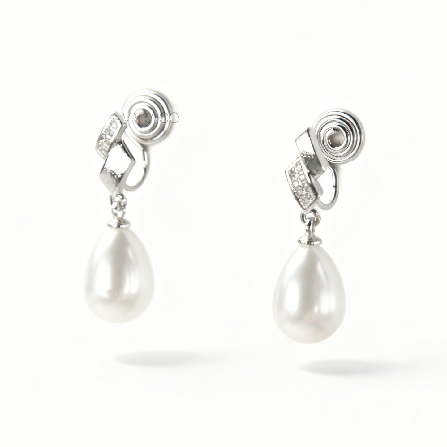 Close-up view of the comfortable coil-back clip mechanism on the gold-tone and silver-tone pearl drop clip-on earrings, showing the secure backing and rhinestone detail.