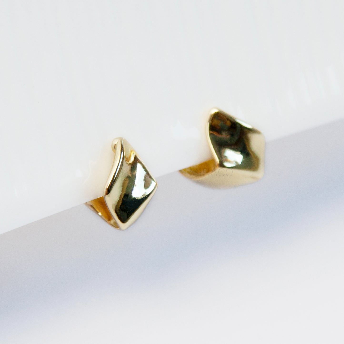 Gold geometric clip-on stud earrings with coil-back clips, minimal modern design for non-pierced ears.