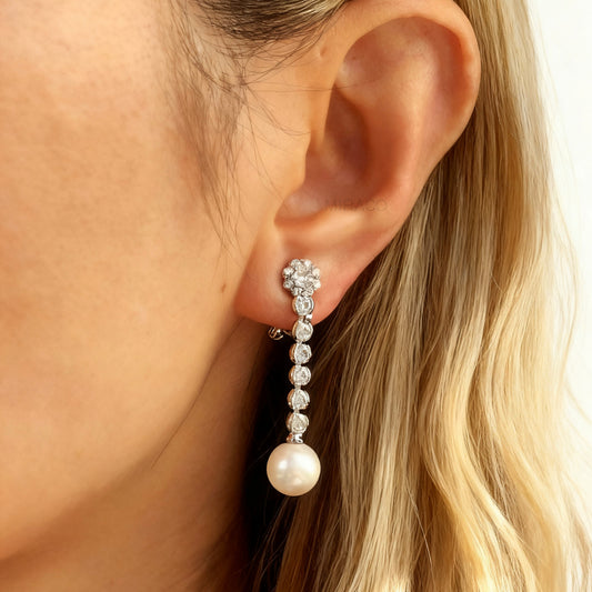 Pair of long dangle clip-on earrings with Mini-Clip back, featuring a paved CZ top and spherical pearl drop