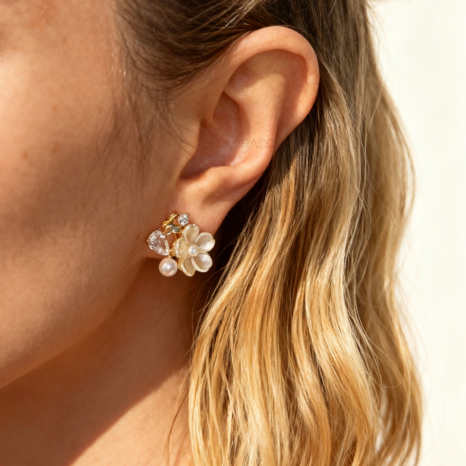 Gold-tone pearl flower clip-on earrings with crystals and coil-back clips for non-pierced ears.