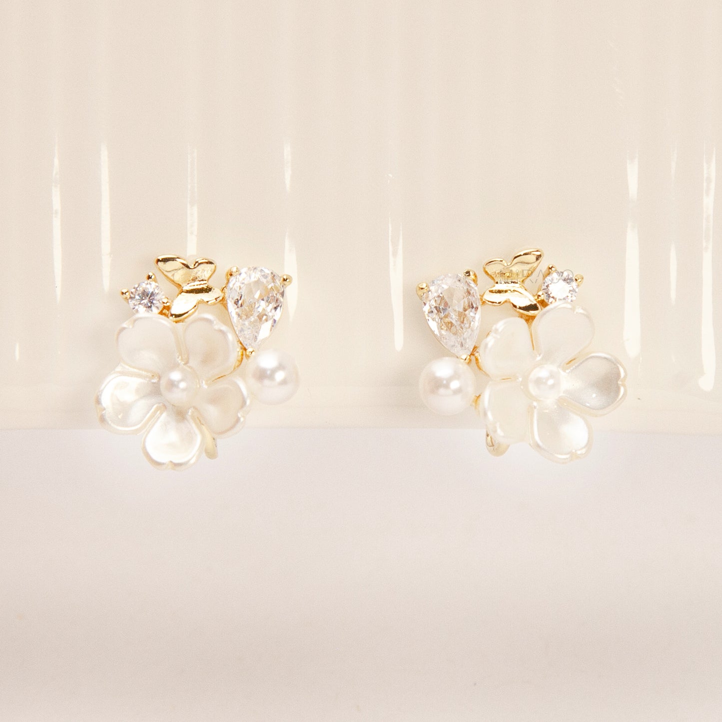 Gold-tone pearl flower clip-on earrings with crystals and coil-back clips for non-pierced ears.