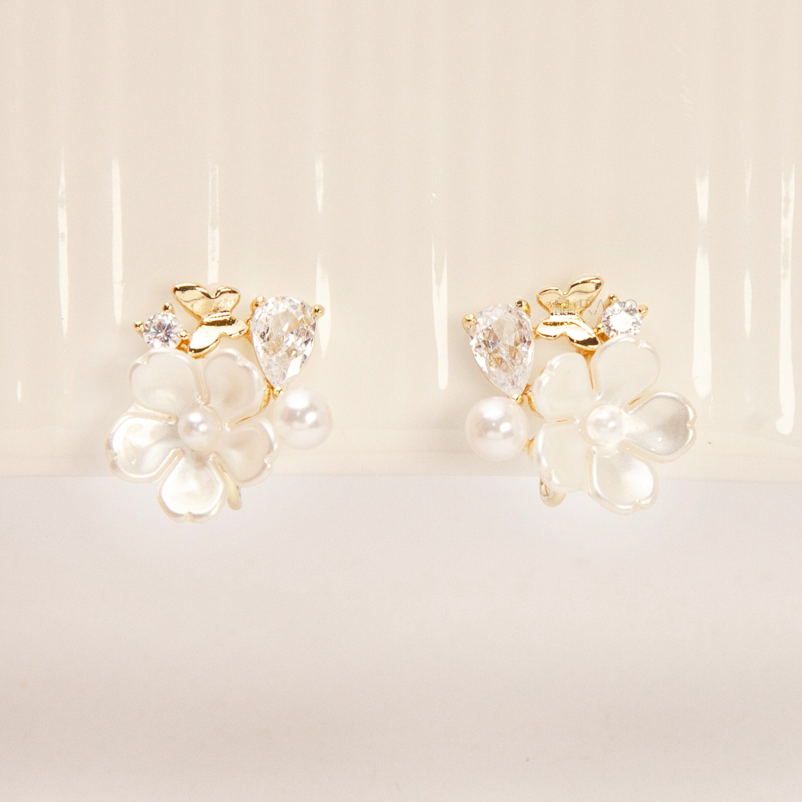 Gold-tone pearl flower clip-on earrings with crystals and coil-back clips for non-pierced ears.