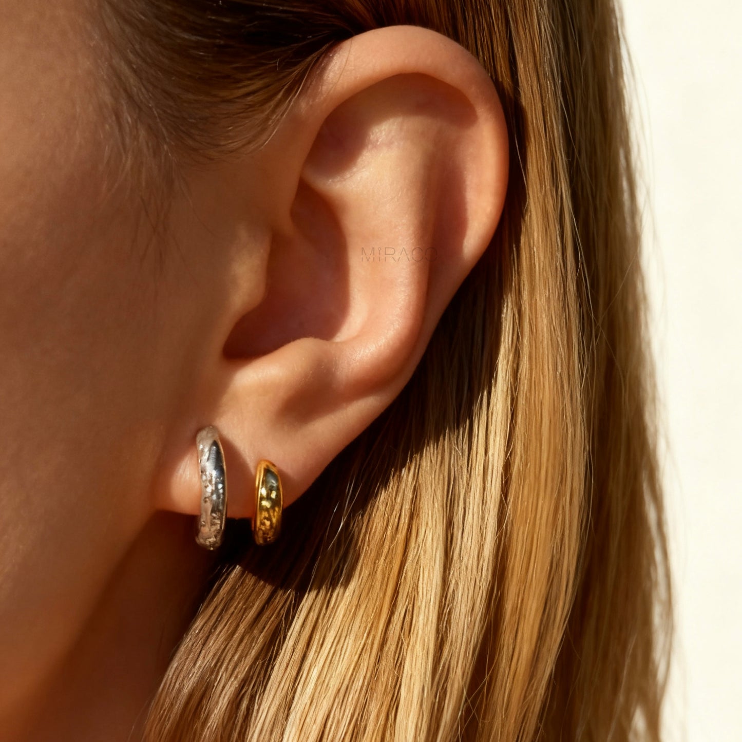 Two-tone double hoop clip-on earrings with textured silver and gold hoops, coil-back design
