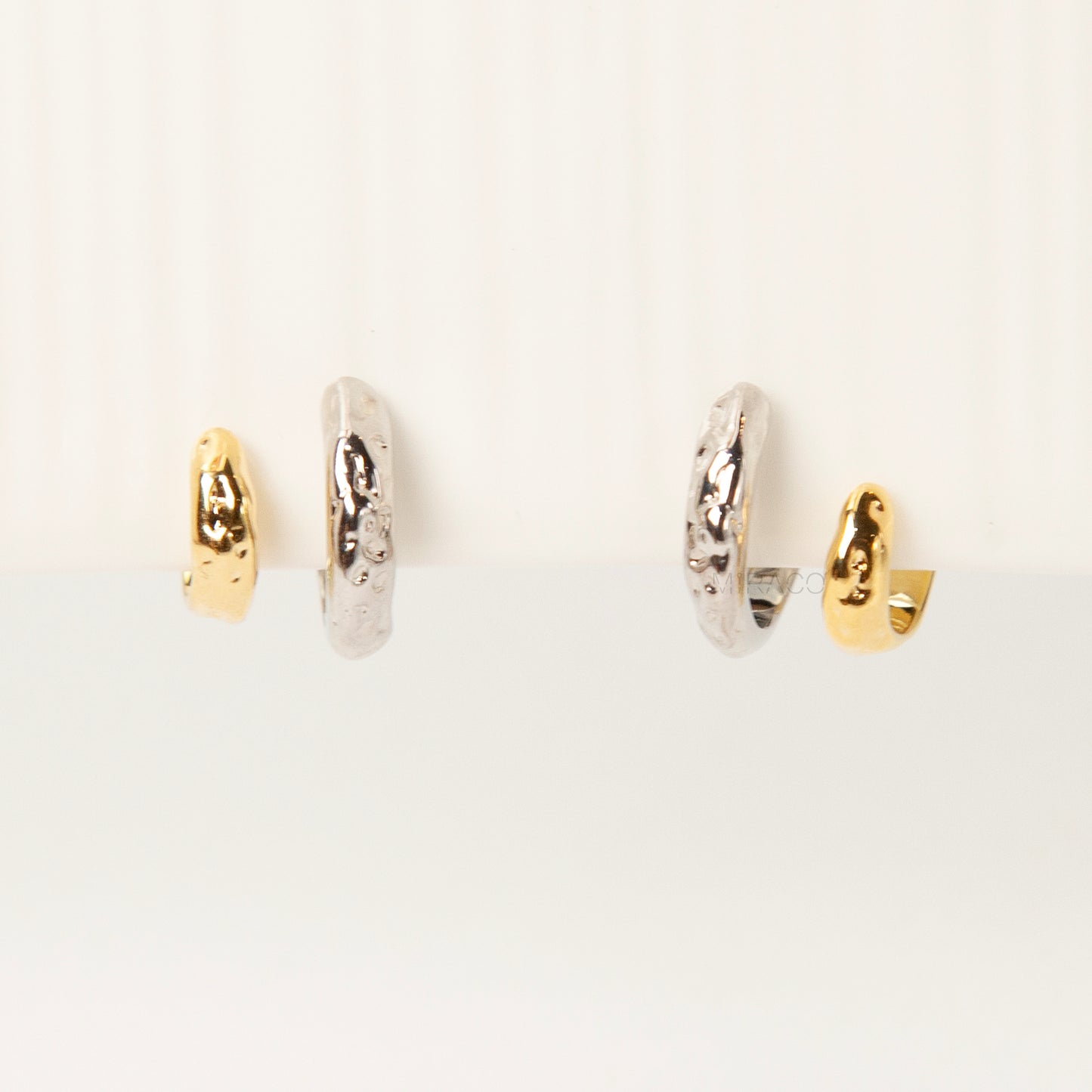 Two-tone double hoop clip-on earrings with textured silver and gold hoops, coil-back design