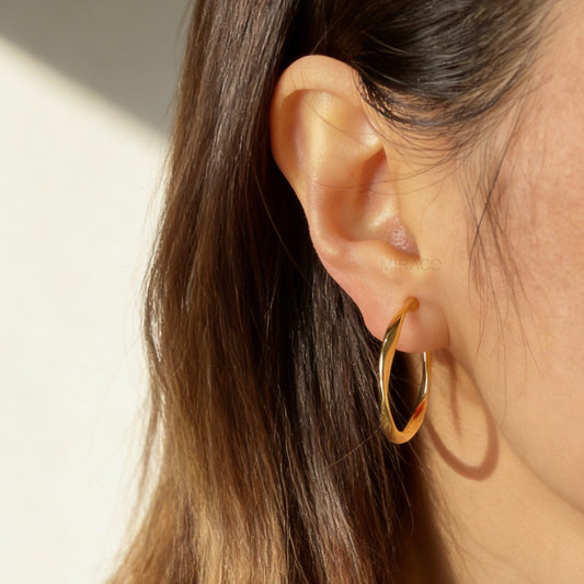 Pair of polished gold twisted hoop clip-on earrings with adjustable screw-back closures