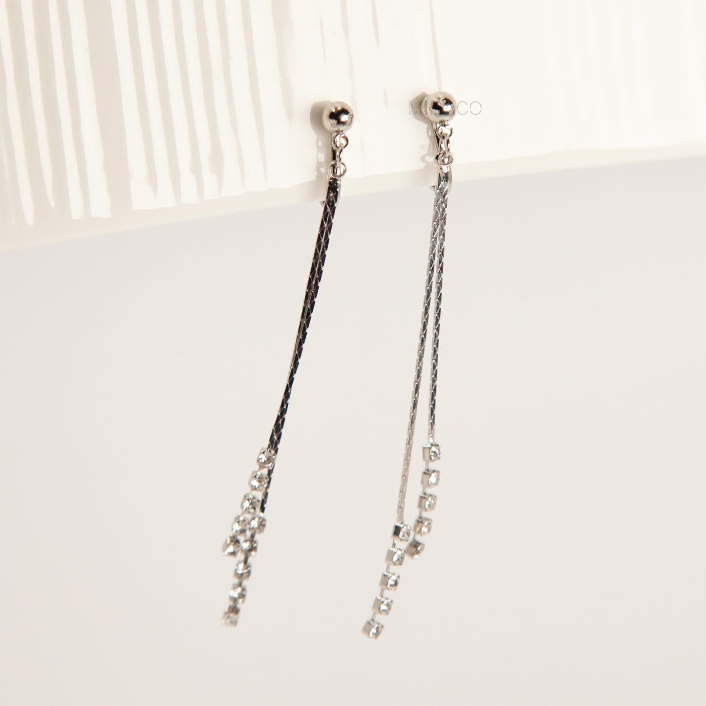 Pair of silver double-strand linear drop clip-on earrings with crystal tips and adjustable screw-back closures on a white background.