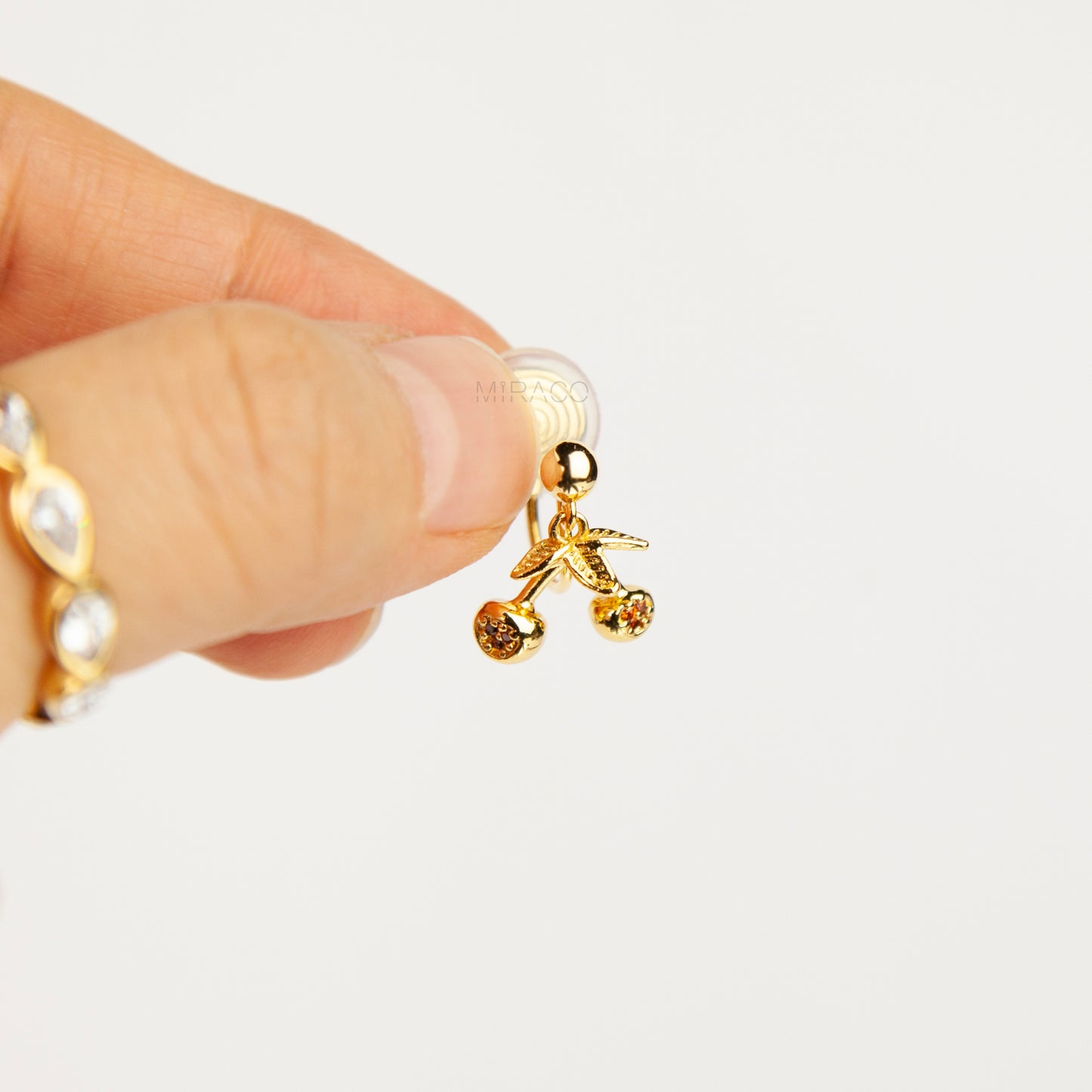 gold-toned double cherry clip-on earrings with amber rhinestone accents and comfortable silicone-backed spiral coil clips.