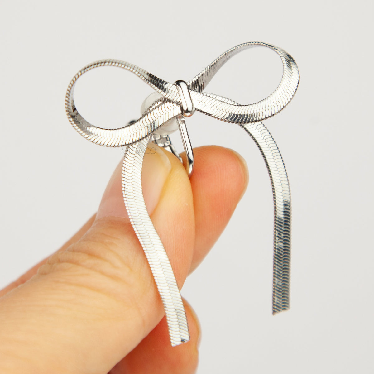 fluid silver snake chain ribbon bow clip-on earrings with adjustable screw backs for non-pierced ears.