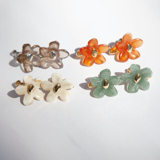Bloom with Effortless Style –&nbsp;Add a delightful touch of floral charm to your look with these adorable flower stud earrings, designed specifically for comfortable clip-on wear. Crafted from polished resin with a lovely translucent or marbled quality, these earrings capture the light beautifully. Each flower features a chic gold-tone center accent.

Available in four versatile color options&nbsp;Smoky Taupe, Vibrant Orange, Cream Marble, Jade Green&nbsp;there's a perfect pair for every mood and outfit!