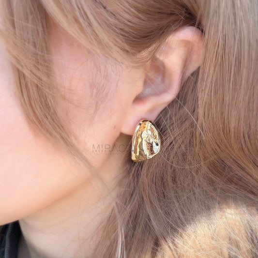 Effortless Elegance, No Piercing Needed.

Make a sophisticated statement without needing pierced ears! These stunning clip-on earrings feature a captivating, organically inspired shape with a beautifully textured surface. Finished in a radiant gold plating, they catch the light exquisitely, adding a touch of modern luxury to any look.

Designed for both style and comfort, these earrings utilize a secure screw-back clip mechanism. This allows you to adjust the tension for a perfect, personalized fit that sta