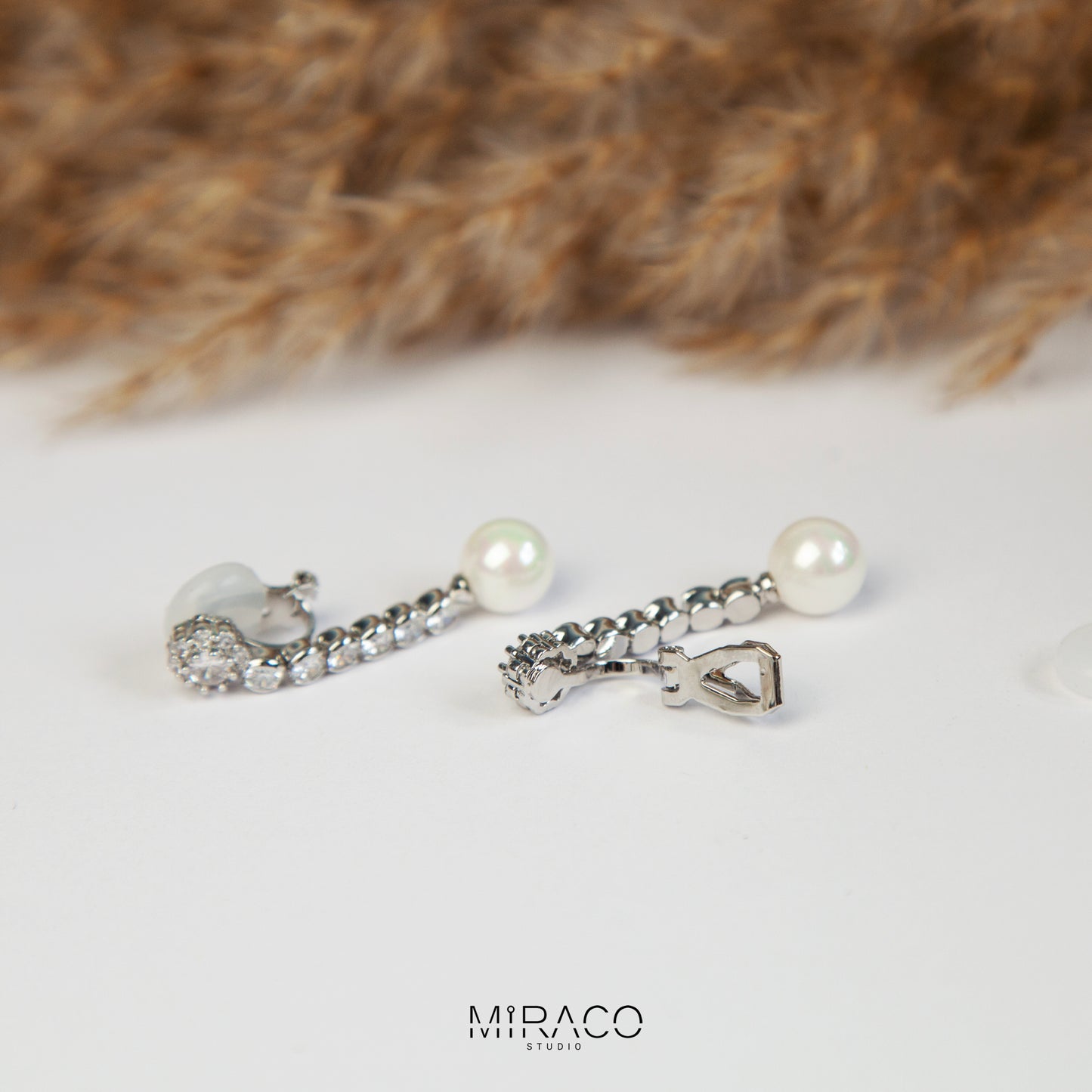 Pair of long dangle clip-on earrings with Mini-Clip back, featuring a paved CZ top and spherical pearl drop