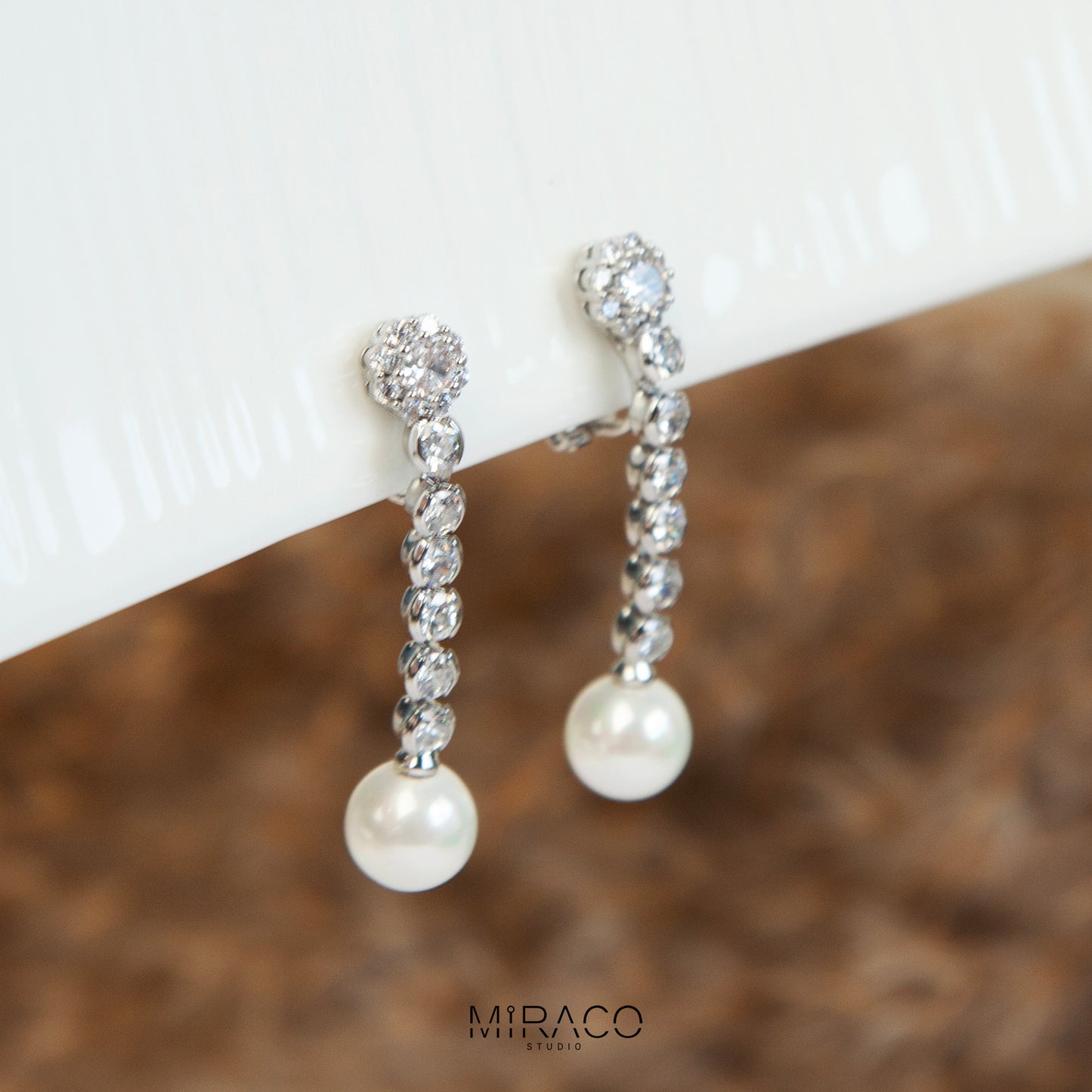Pair of long dangle clip-on earrings with Mini-Clip back, featuring a paved CZ top and spherical pearl drop