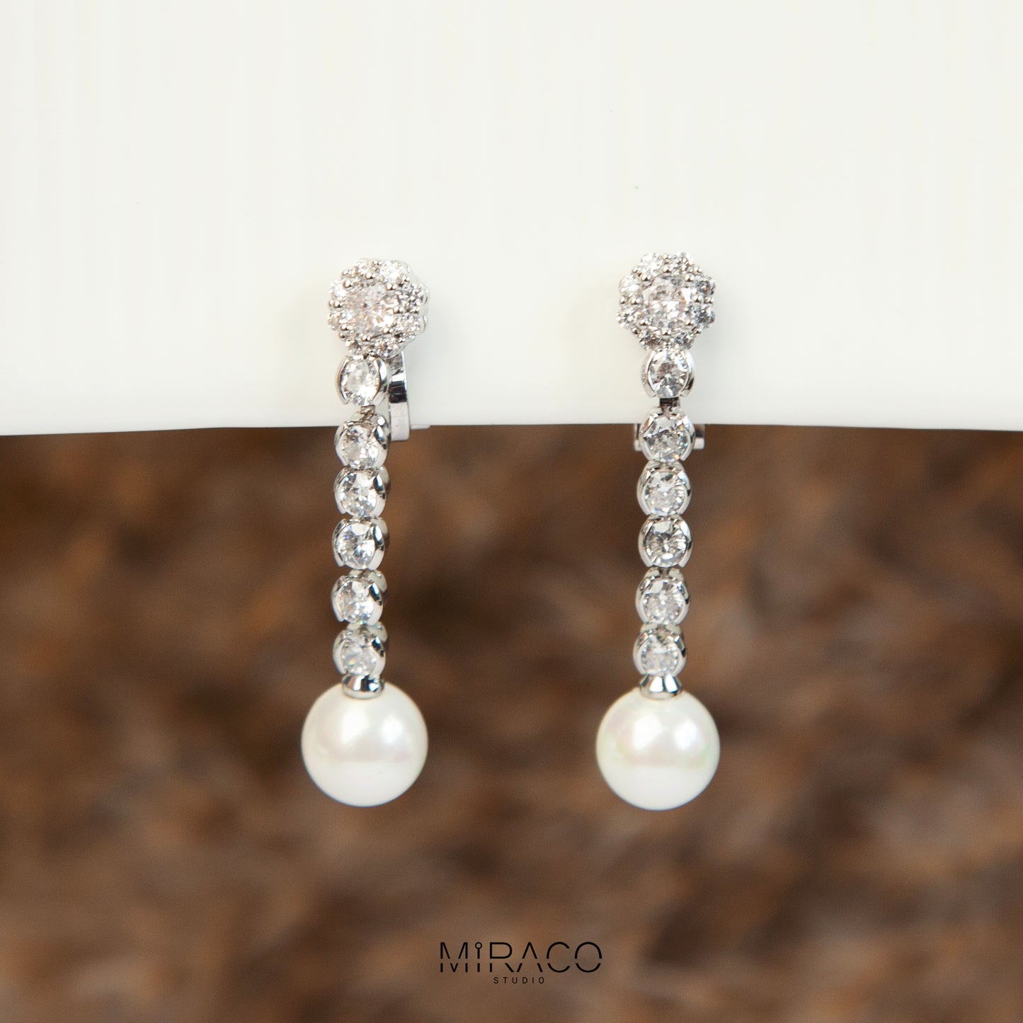 Pair of long dangle clip-on earrings with Mini-Clip back, featuring a paved CZ top and spherical pearl drop