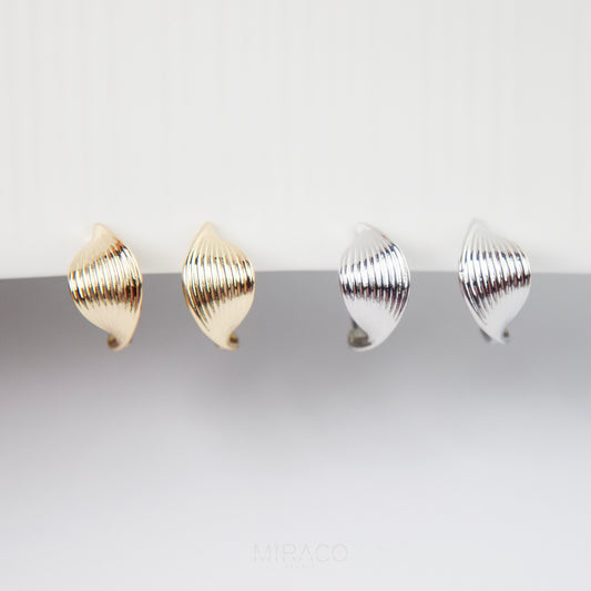 Two pairs of gold and silver earrings on a white background clip on earrings