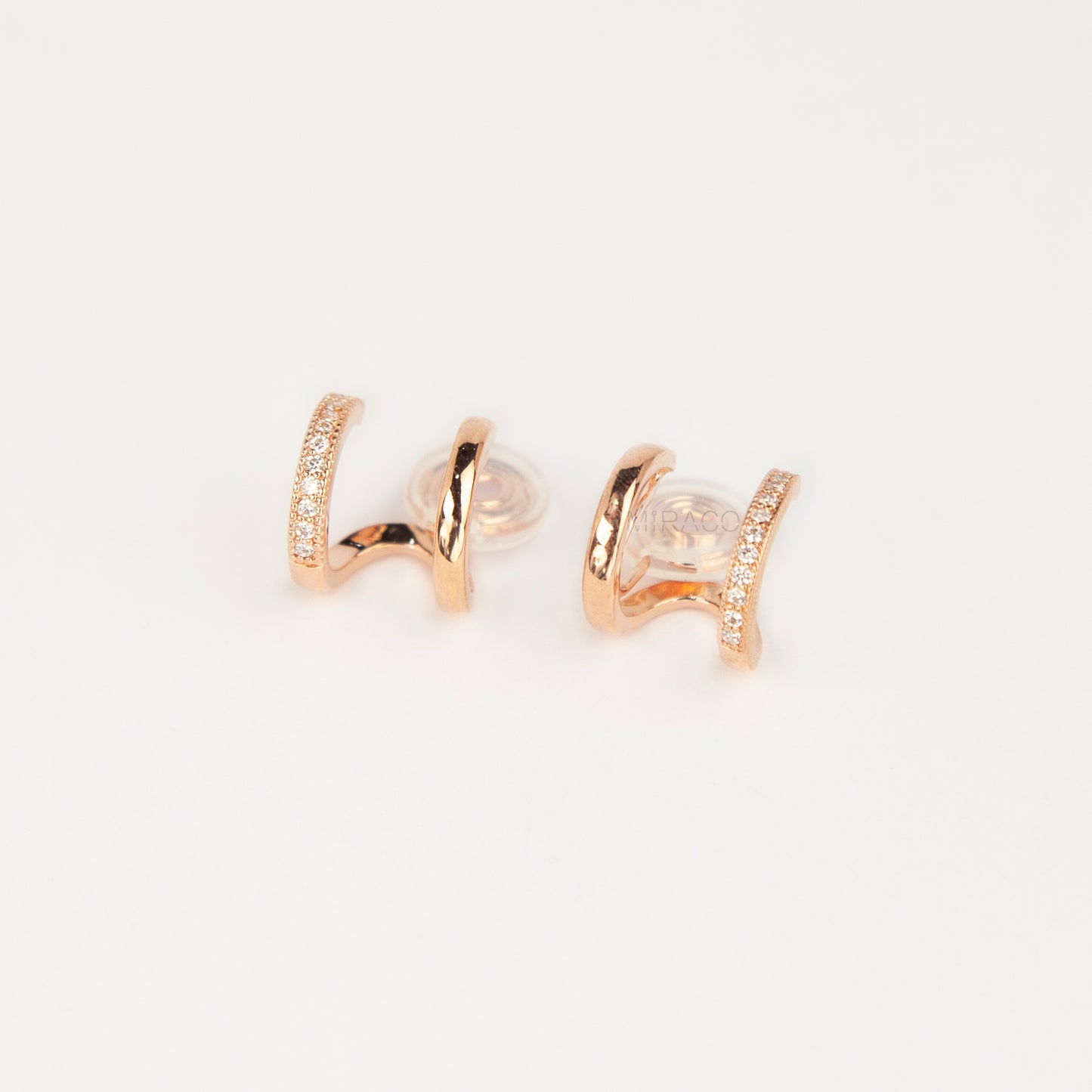 Pair of rose gold non-pierced double band clip-on hoop earrings with pavé cubic zirconia accents and clear silicone spiral coil backs.