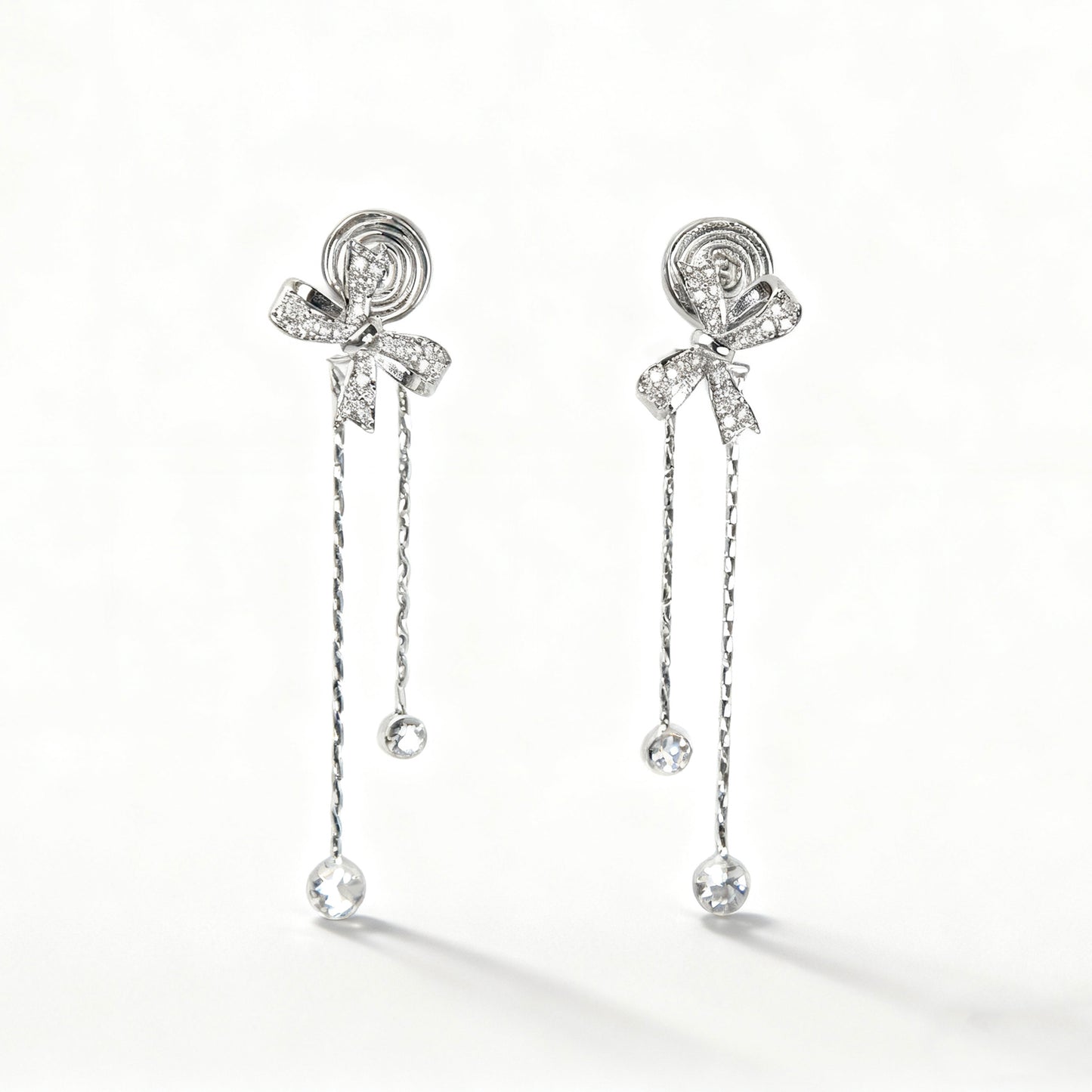 Pair of silver earrings with bow and chain design clip on dangle droop earrings