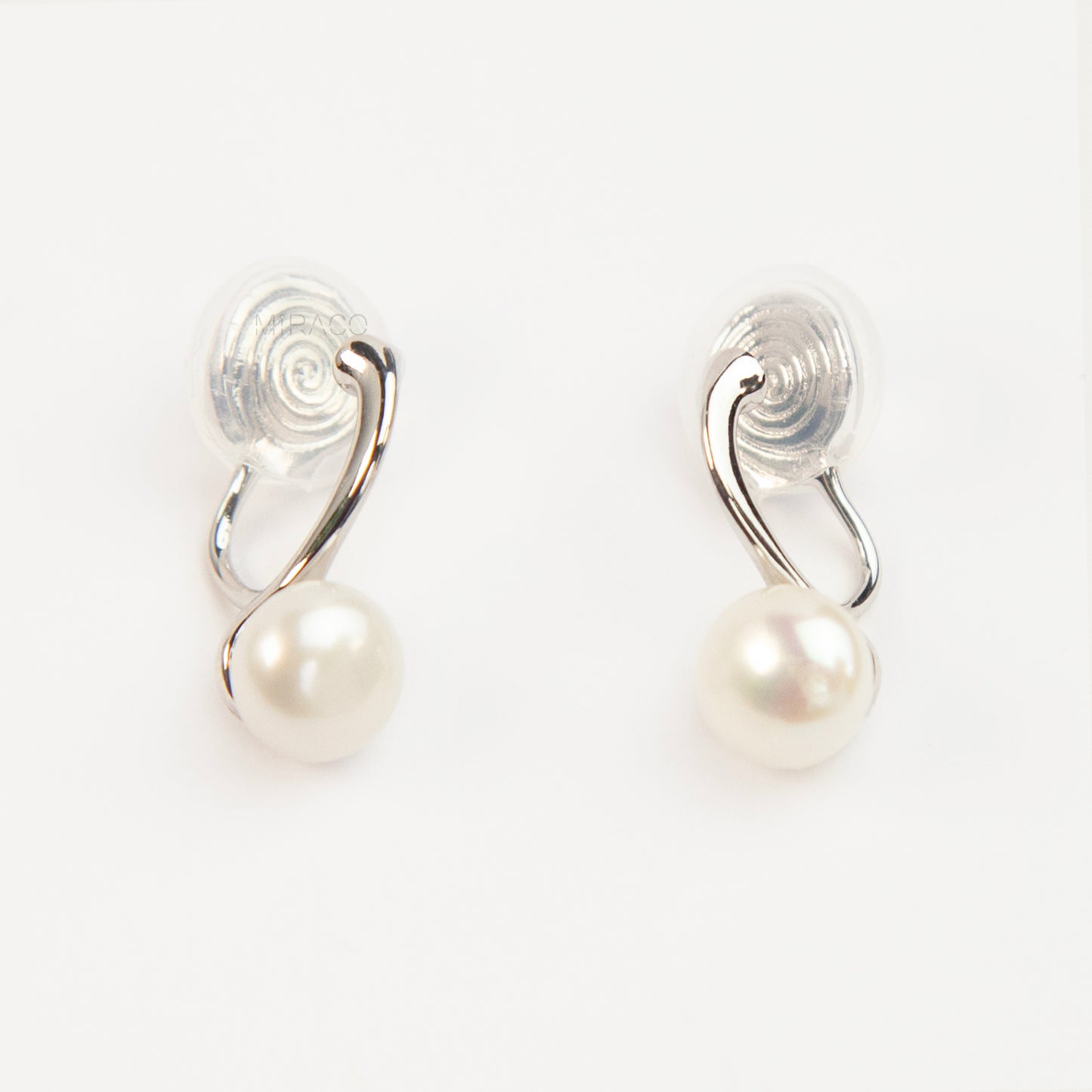 A pair of silver-tone clip-on earrings featuring a single round genuine white pearl dangling from a sleek curved metal bar, equipped with adjustable coil-spring backs