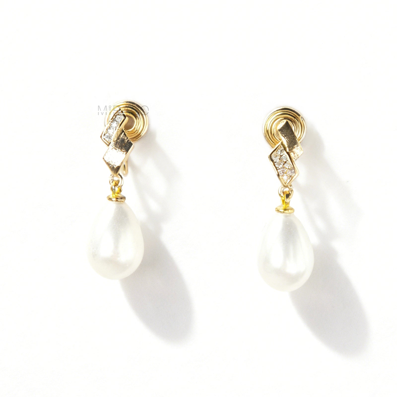 Close-up view of the comfortable coil-back clip mechanism on the gold-tone and silver-tone pearl drop clip-on earrings, showing the secure backing and rhinestone detail.