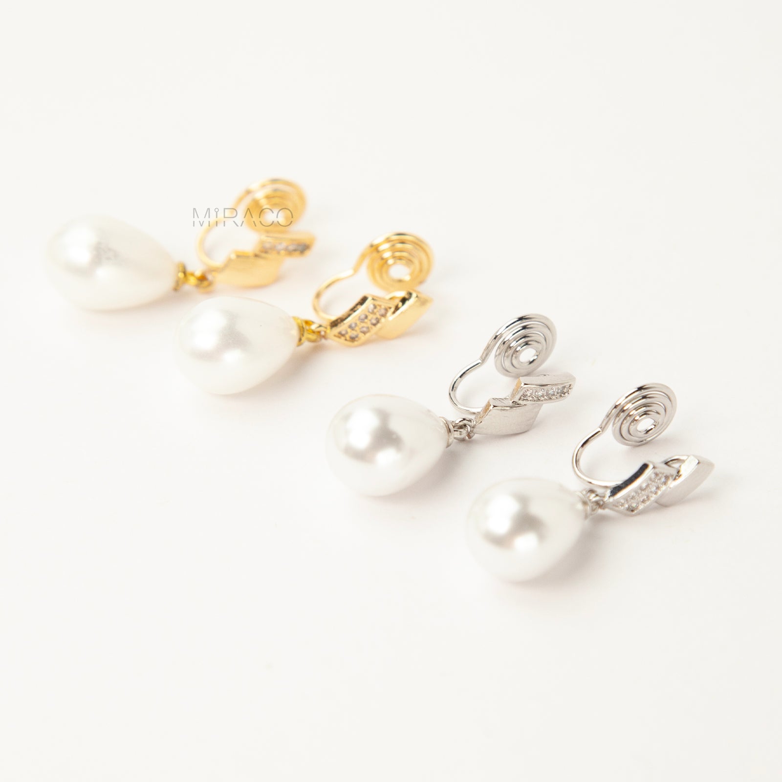 Close-up view of the comfortable coil-back clip mechanism on the gold-tone and silver-tone pearl drop clip-on earrings, showing the secure backing and rhinestone detail.