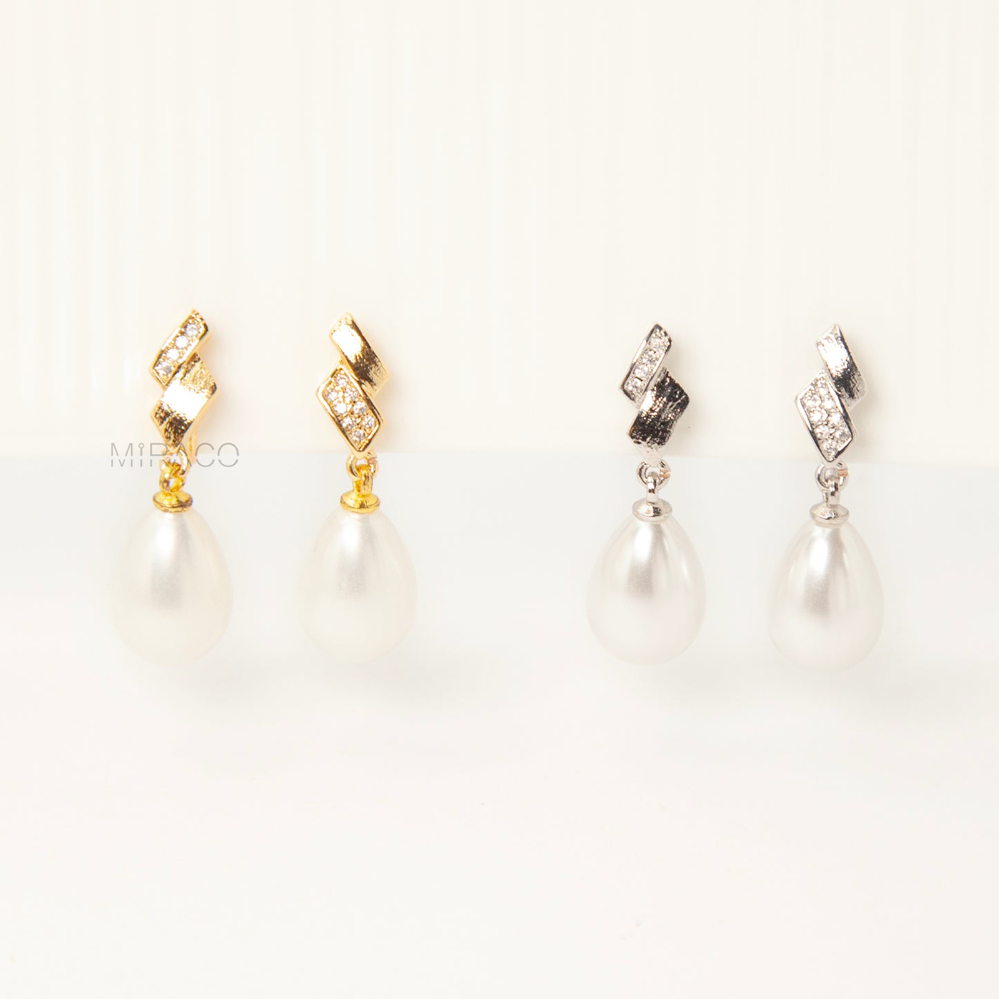 Close-up view of the comfortable coil-back clip mechanism on the gold-tone and silver-tone pearl drop clip-on earrings, showing the secure backing and rhinestone detail.