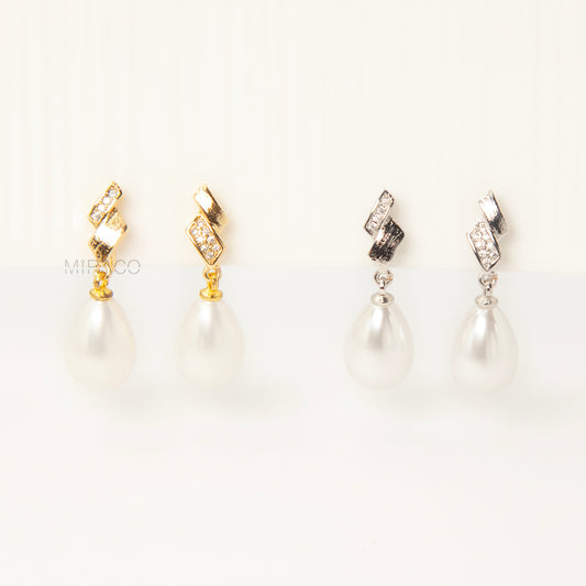 Close-up view of the comfortable coil-back clip mechanism on the gold-tone and silver-tone pearl drop clip-on earrings, showing the secure backing and rhinestone detail.