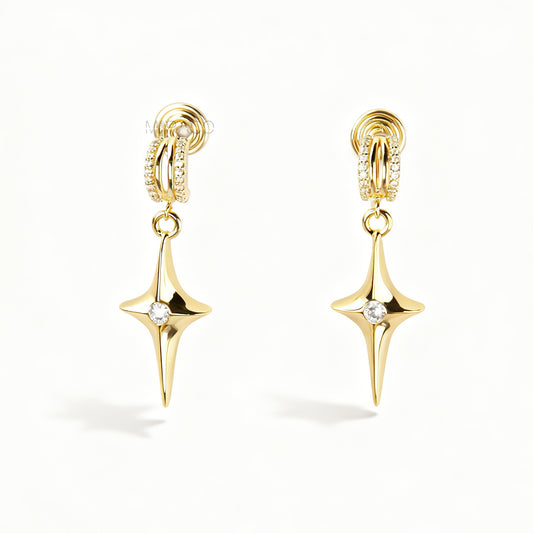 A pair of gold-toned dangle clip-on earrings featuring a modern, four-point North Star pendant centered with a clear rhinestone. The top closure is a comfortable coil-back style, partially covered with pave-set rhinestones.