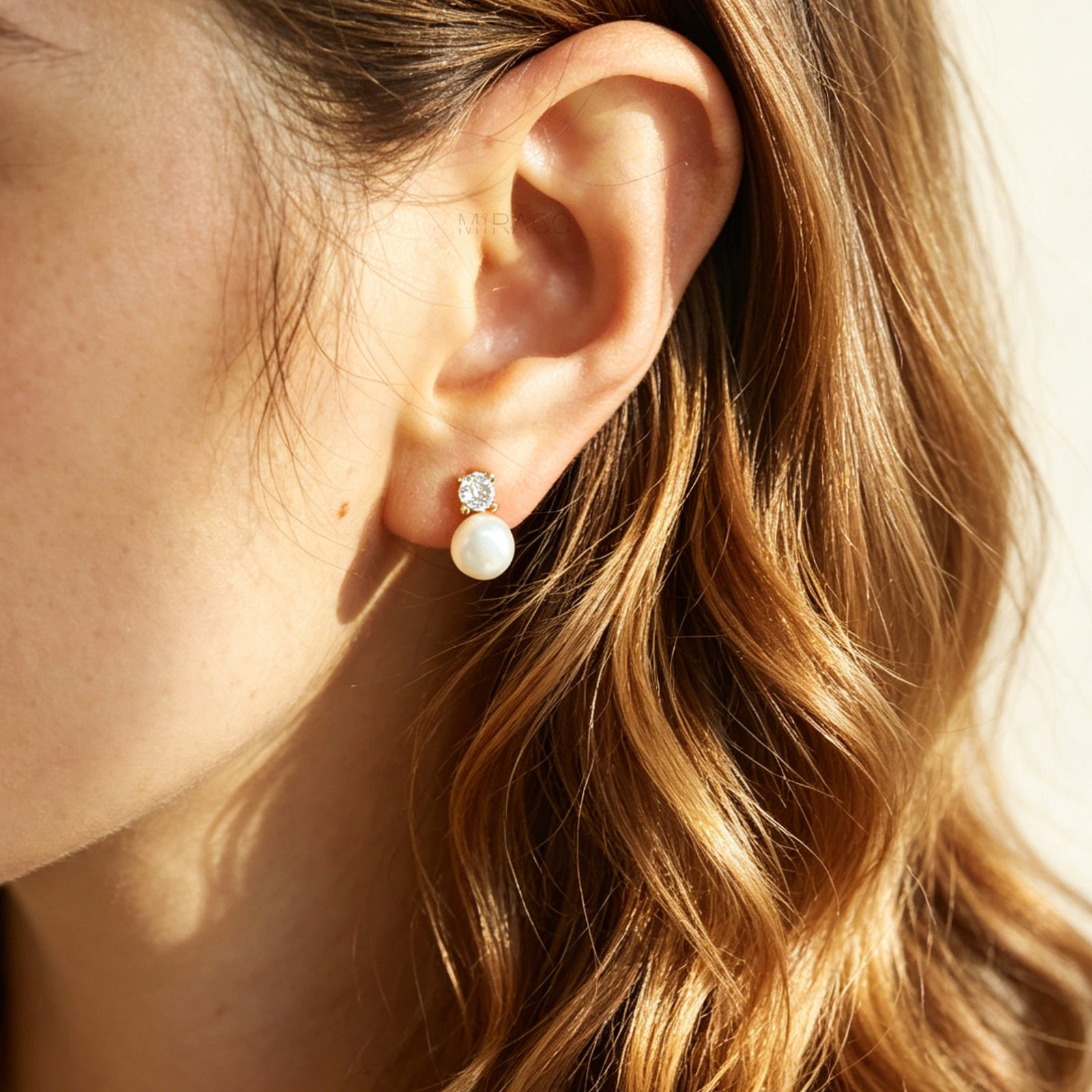 Close-up of an ear wearing a pearl earring with a blurred background