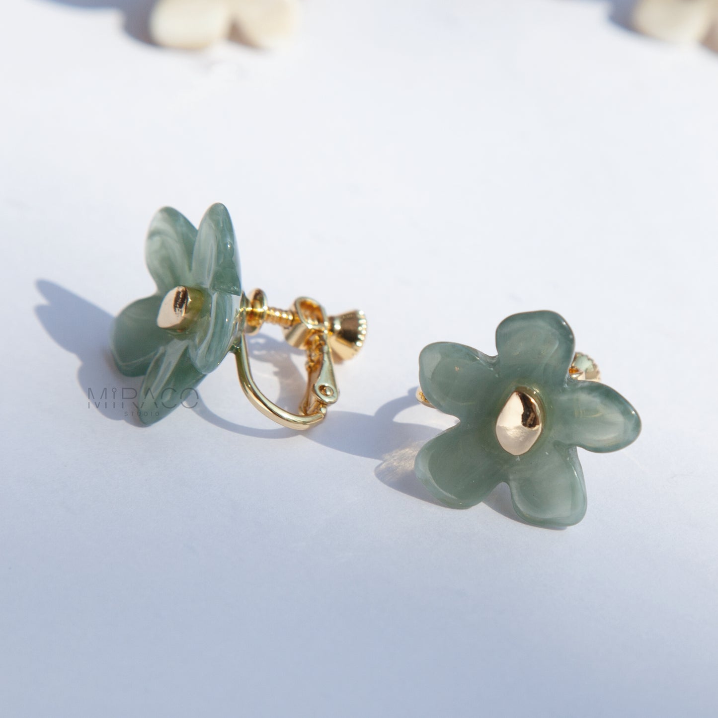 Bloom with Effortless Style –&nbsp;Add a delightful touch of floral charm to your look with these adorable flower stud earrings, designed specifically for comfortable clip-on wear. Crafted from polished resin with a lovely translucent or marbled quality, these earrings capture the light beautifully. Each flower features a chic gold-tone center accent.

Available in four versatile color options&nbsp;Smoky Taupe, Vibrant Orange, Cream Marble, Jade Green&nbsp;there's a perfect pair for every mood and outfit!