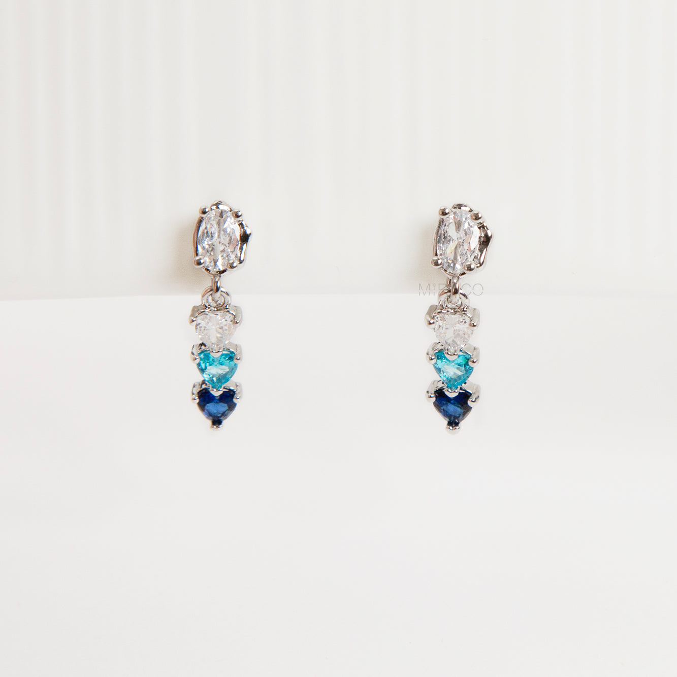 Pair of clip on earrings with heart-shaped gemstones, blue and white gem stone