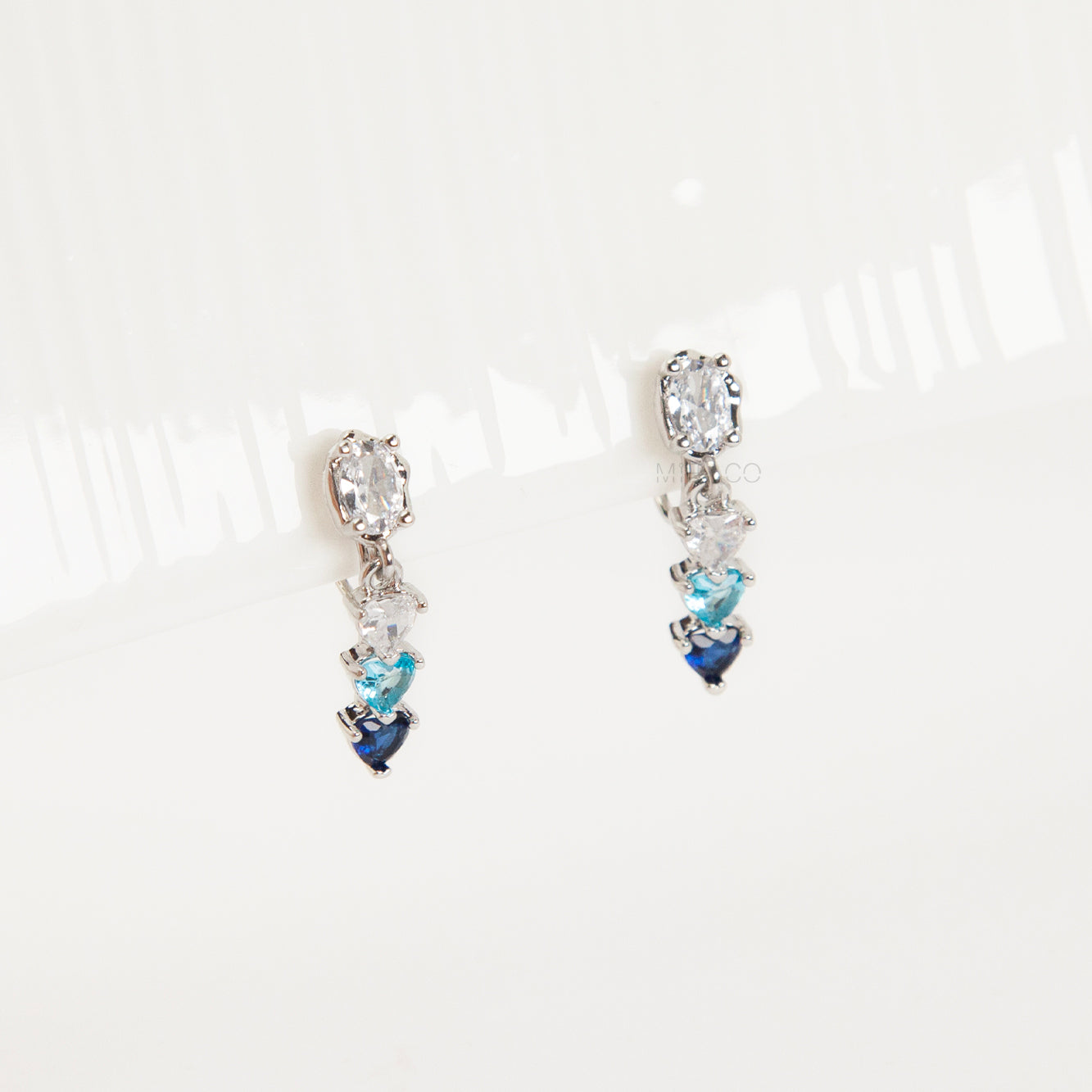 Pair of clip on earrings with heart-shaped gemstones, blue and white gem stone