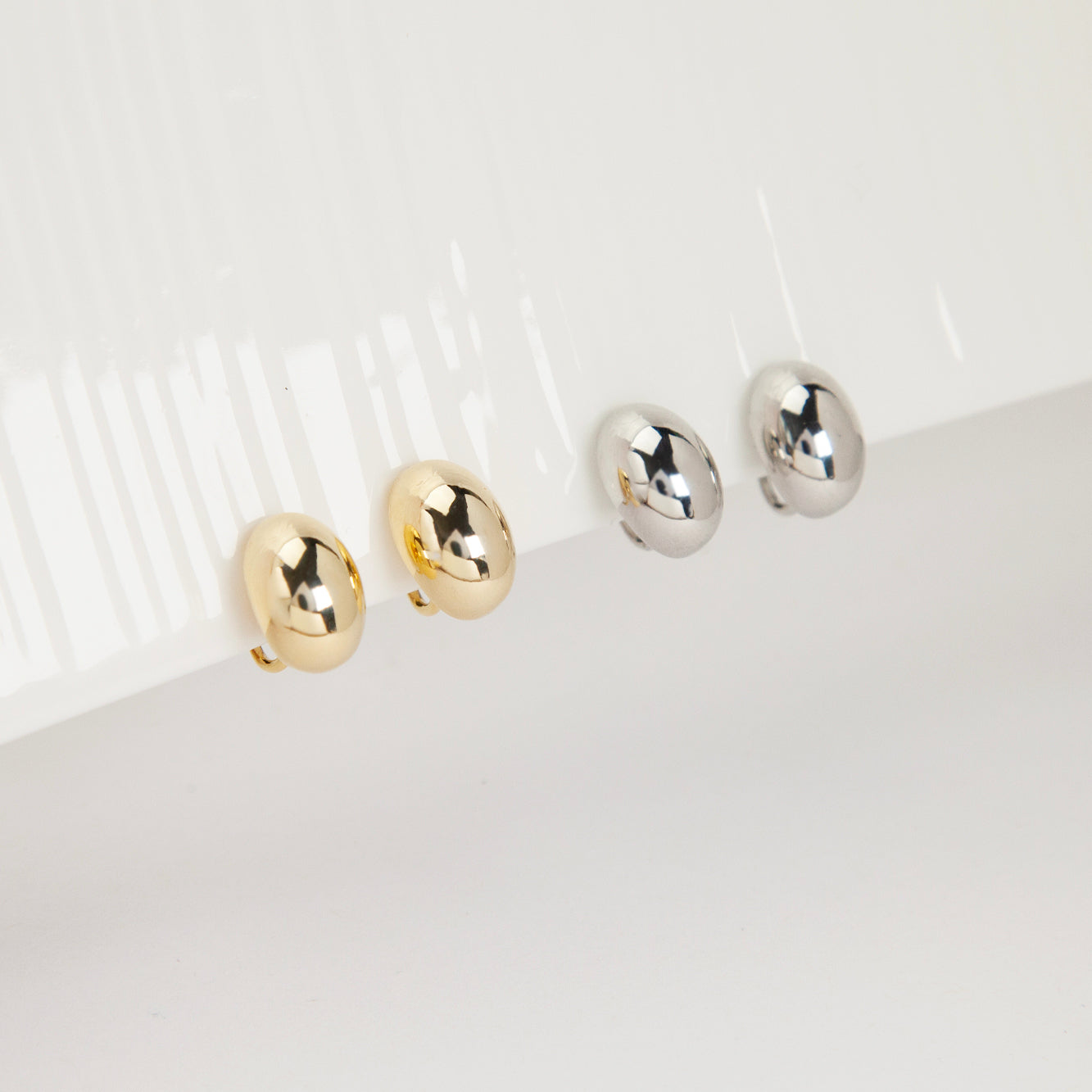 clip-on earrings, silver clip-on earrings, gold clip-on earrings, oval stud earrings, minimalist earrings, non-pierced earrings, U-shape coil clip-on, everyday stud earrings, polished oval earrings, lightweight clip-on earrings