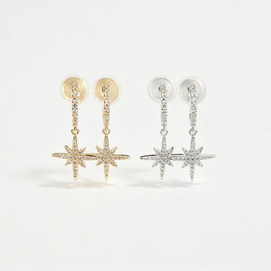 Gold and silver non-pierced clip-on dangle earrings with coil backs, featuring cubic zirconia paved hoops and celestial starburst drops.