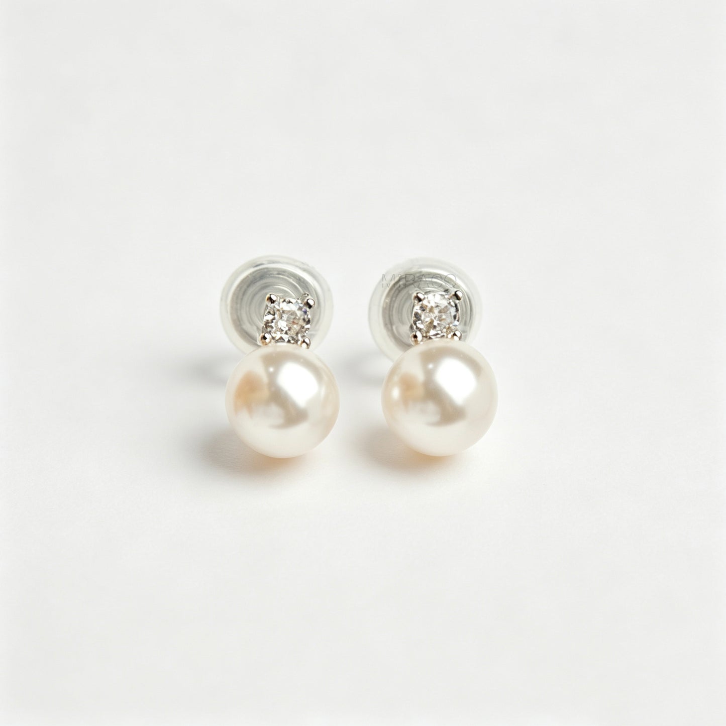 silver-tone non-pierced clip-on earring featuring a round white pearl drop suspended from a sparkling cubic zirconia solitaire with a coil back.