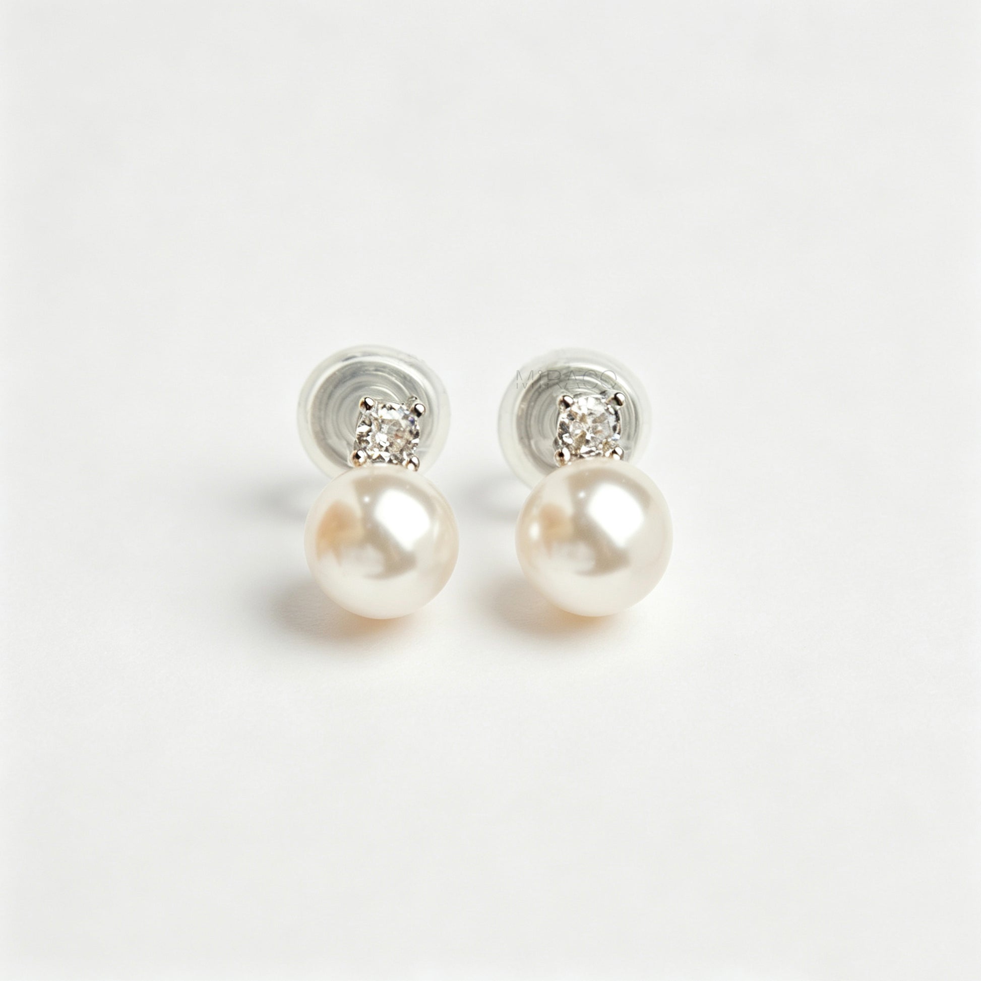 silver-tone non-pierced clip-on earring featuring a round white pearl drop suspended from a sparkling cubic zirconia solitaire with a coil back.