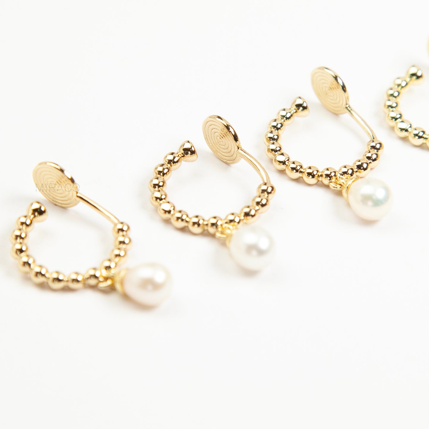 gold beaded hoop clip-on earring with a dangling pearl