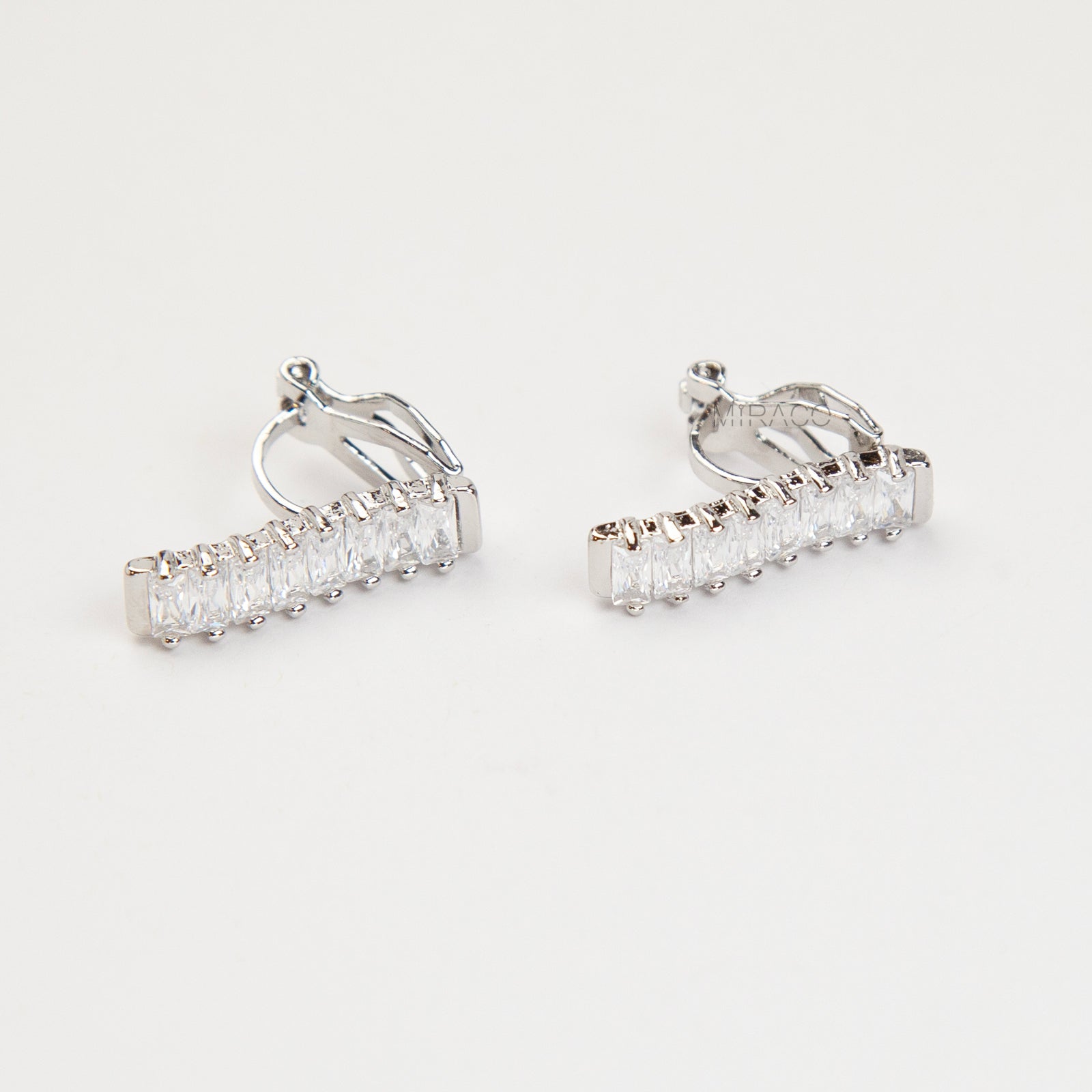 Pair of silver-tone vertical bar clip-on earrings featuring a column of rectangular baguette-cut cubic zirconia stones.