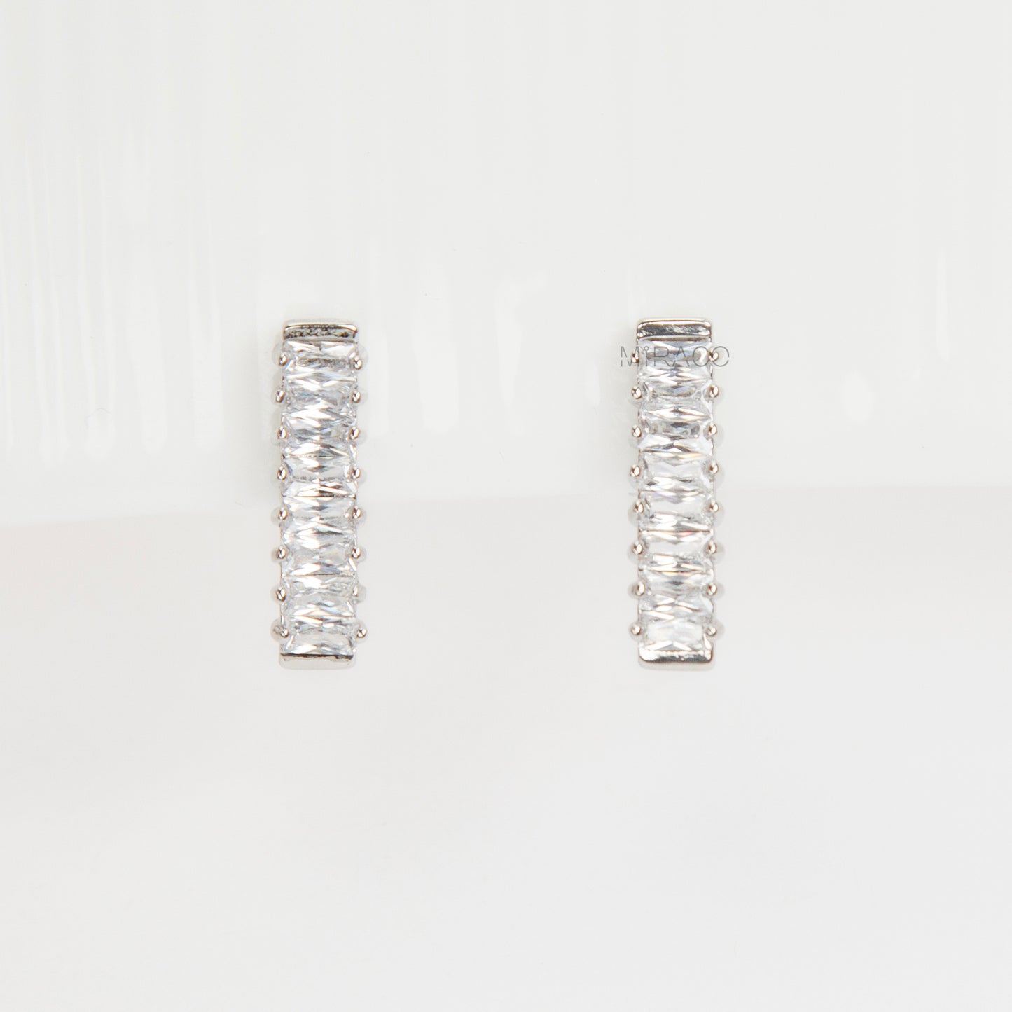 Pair of silver-tone vertical bar clip-on earrings featuring a column of rectangular baguette-cut cubic zirconia stones.