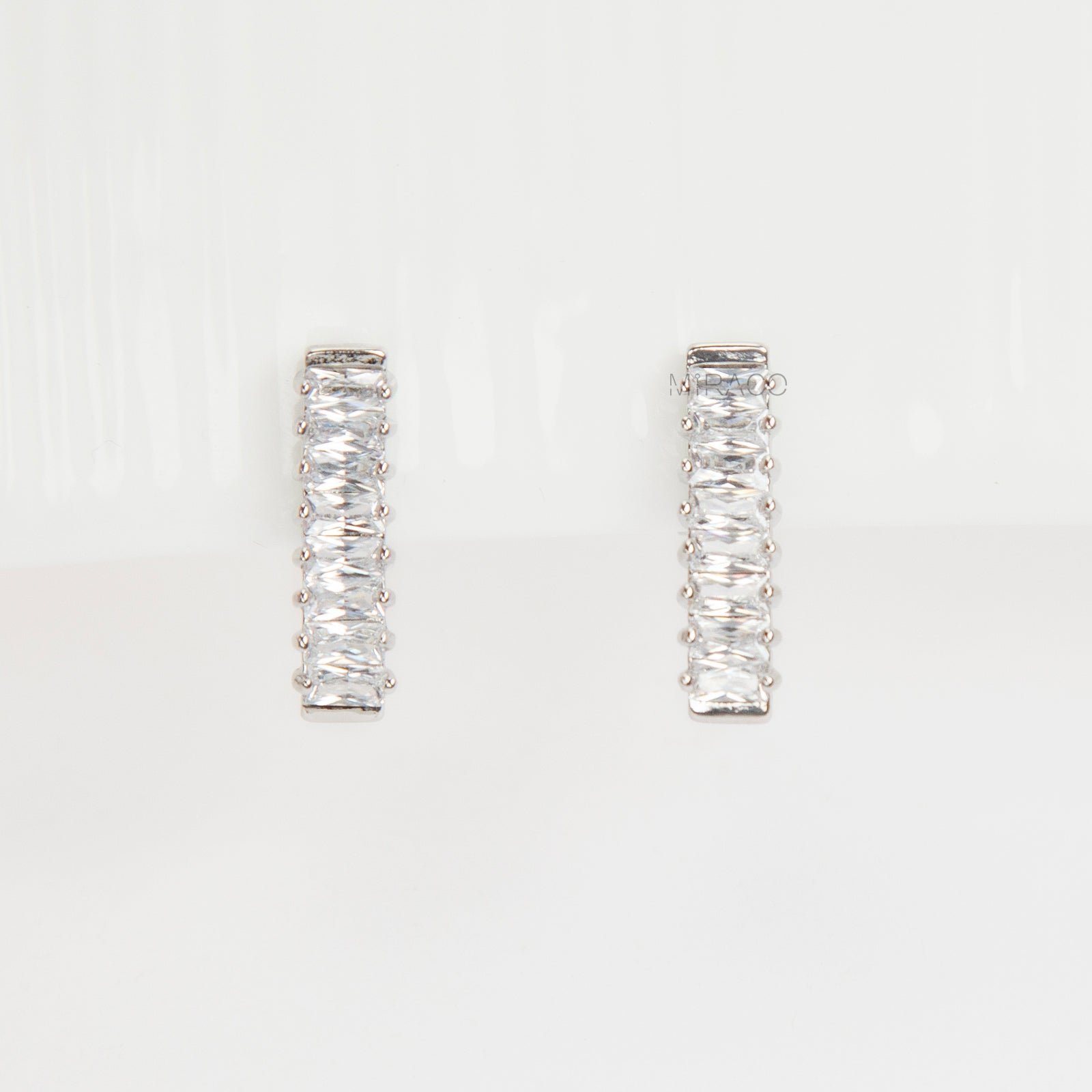 Pair of silver-tone vertical bar clip-on earrings featuring a column of rectangular baguette-cut cubic zirconia stones.
