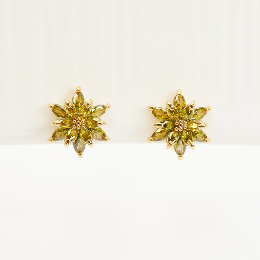 Pair of gold-tone clip-on earrings shaped like a flower or starburst, featuring marquise-cut peridot green crystals radiating from the center.