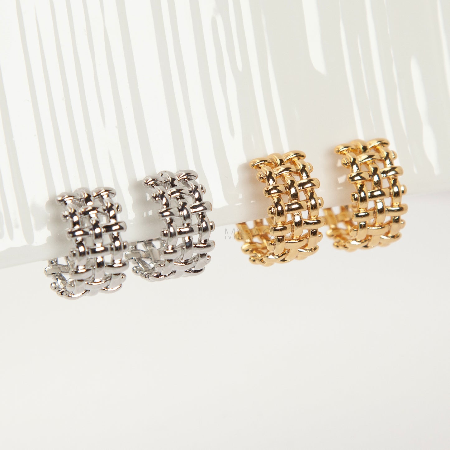 woven mesh coil back clip-on earrings on white background. Two are in silver tone and two are in gold tone. Shows the basketweave texture and the clear coil-back mechanism.