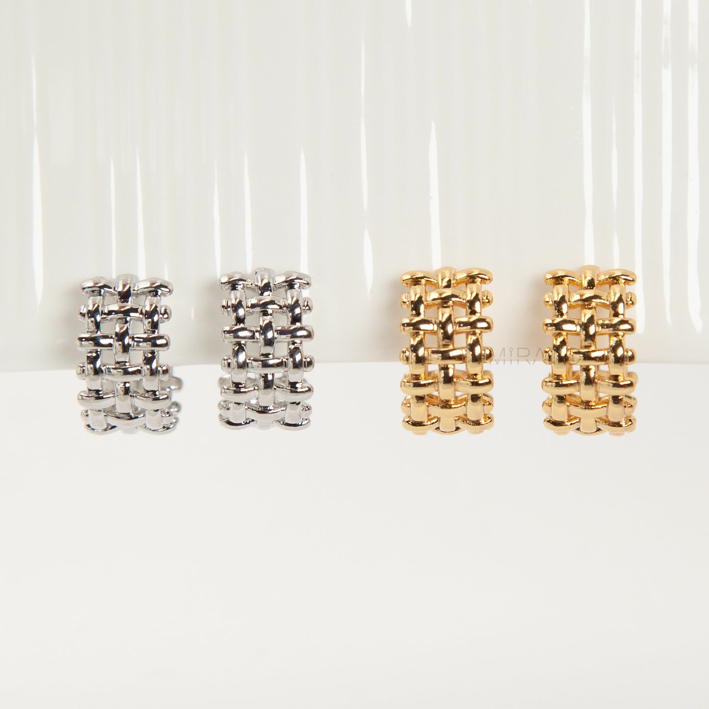 woven mesh coil back clip-on earrings on white background. Two are in silver tone and two are in gold tone. Shows the basketweave texture and the clear coil-back mechanism.