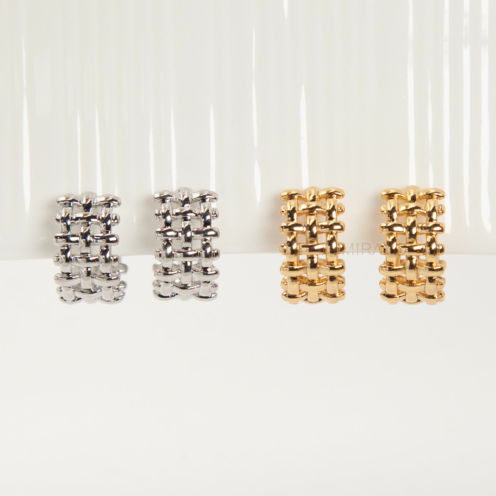 woven mesh coil back clip-on earrings on white background. Two are in silver tone and two are in gold tone. Shows the basketweave texture and the clear coil-back mechanism.