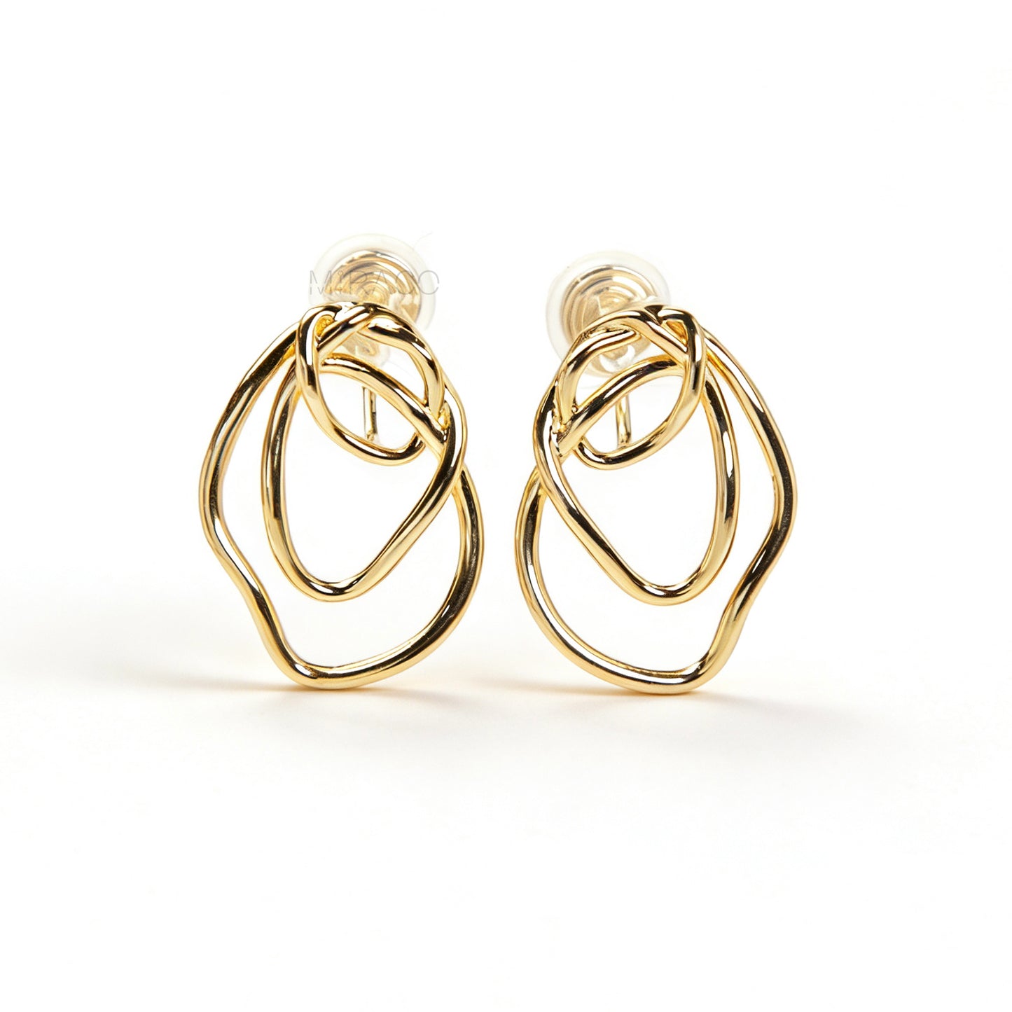 Close-up of comfortable gold-tone interlocking clip-on earrings featuring a modern, abstract double-ring design and a secure clear coil back closure. Non-pierced statement jewelry.