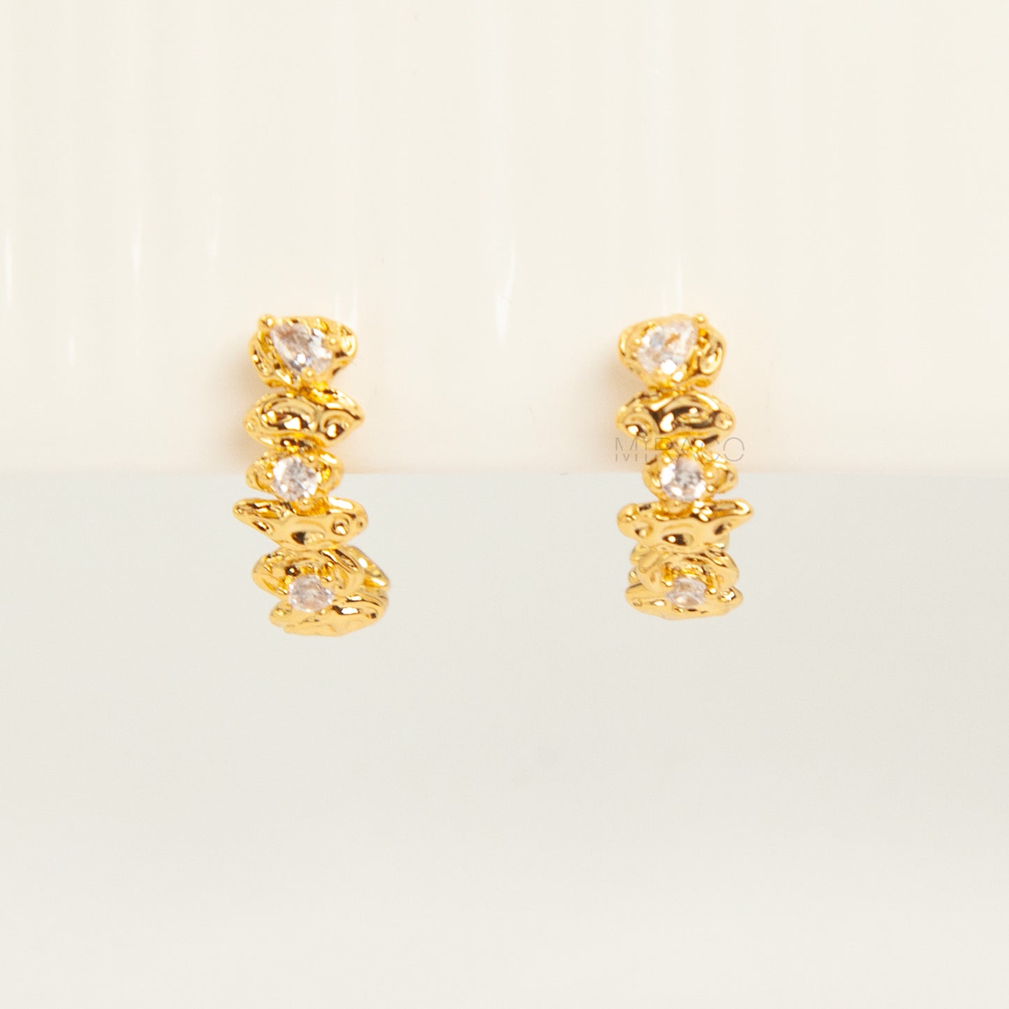 Gold-tone dangle clip-on earrings featuring stacked clear stones and a secure coil-back closure.